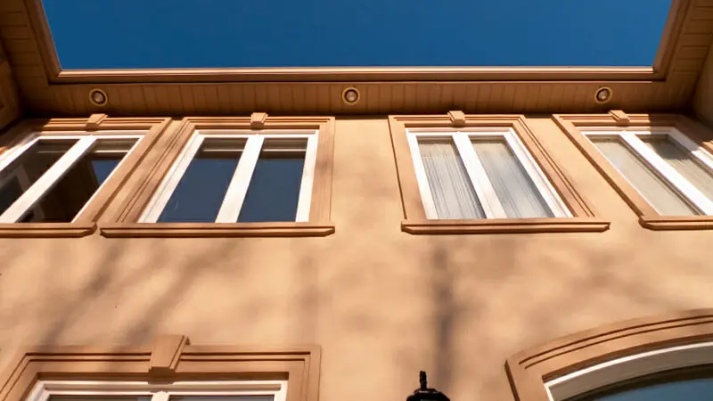 Decorative stucco bands and window surrounds shaped on a warm-toned exterior wall
