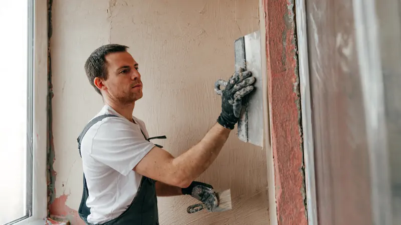 Interior plastering, a smooth gypsum plaster coat troweled onto an interior wall